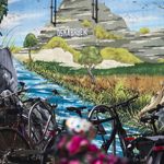 Bunte Graffiti-Kunst in Osnabrück, die die kreative und grüne Seite der Stadt zeigt, eingerahmt von parkenden Fahrrädern.